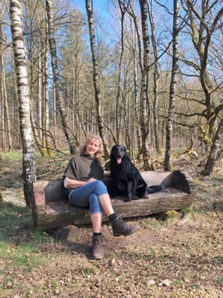 Helena en Mazzel op een bankje op de rand van een berkenbos op Donderslaghei. De bank is uitgezaagd uit een dikke eiken stam.
